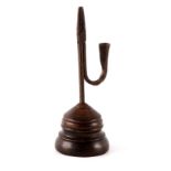 AN 18TH/19TH CENTURY RUSH LIGHT having a hinged wrought iron stand on turned wood base 25cm high