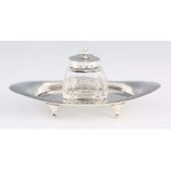 AN EDWARD VII CENTURY SMALL SILVER INKSTAND comprising a dished tray and silver-mounted glass