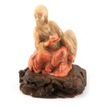 A 19TH CENTURY CHINESE CARVED AND ENGRAVED SOAPSTONE SCULPTURE ON CARVED HARDWOOD STAND modelled