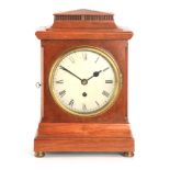 AN EARLY 20TH CENTURY WALNUT CASED SINGLE FUSEE MANTEL CLOCK the chamfered moulded pediment above