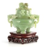 A LARGE CHINESE JADE KORO AND COVER surmounted by two foo dogs on a domed lid with lion head hoops