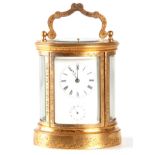 JAPY FRERES AND CO. A 19TH CENTURY ENGRAVED GILT OVAL CASED REPEATING FRENCH CARRIAGE CLOCK having a