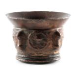 A 17TH CENTURY BRONZE MORTAR with shaped side handles and cast medallions 10cm high 14cm diameter.