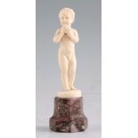 FERDINAND PRIESS. AN ART DECO CARVED IVORY FIGURE modelled as a naked boy with apple mounted on a