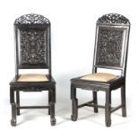 A PAIR OF CHINESE HARDWOOD CHIRS with carved pierced top rails above carved panelled backs and pad