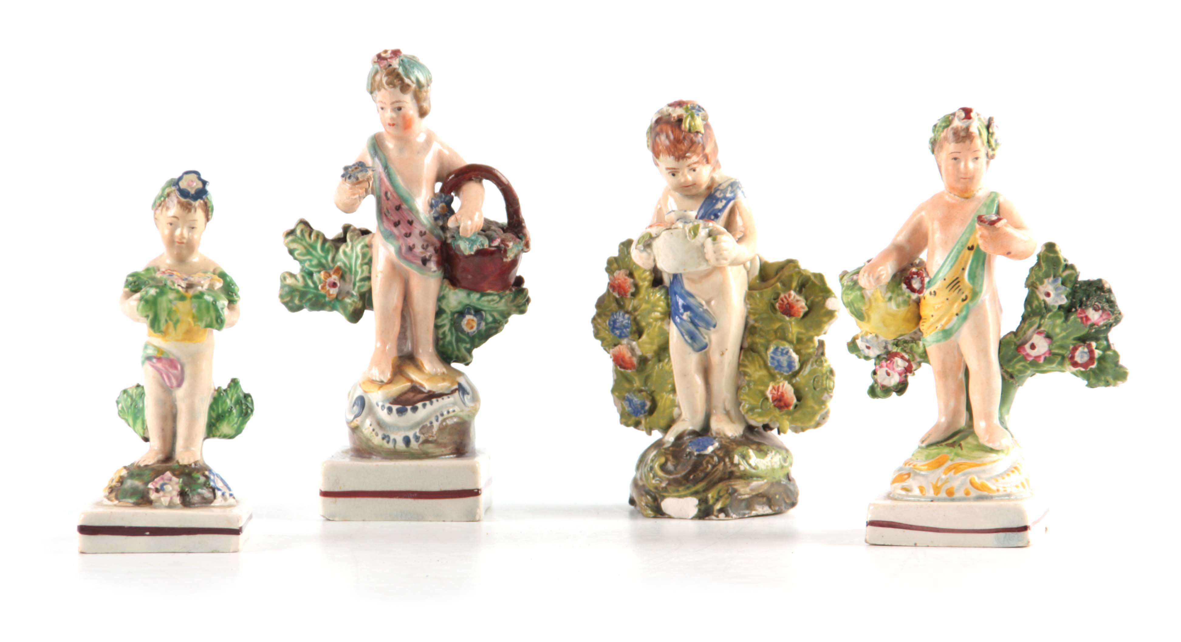 A SELECTION OF FOUR EARLY 19TH CENTURY STAFFORDSHIRE PEARLWARE FIGURES of cherubs holding various
