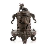 A 19TH CENTURY CHINESE BRONZE CENSER with pierced cylindrical top decorated with a dragon finial,