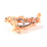 A 19TH CENTURY CORAL AND DIAMOND SET BROOCH with foliate carved decoration set with 22 old cut