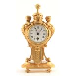 A LATE 19TH CENTURY FRENCH GILT MANTEL CLOCK the case flanked by cherubs on hoof feet enclosing a