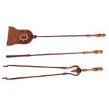 A SET OF THREE 19TH CENTURY BRASS AND STEEL FIRE IRONS with cast gilt handles and turned stems;