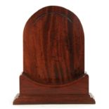 A 19TH CENTURY MAHOGANY PLATE STAND with arched back and dished weighted base on a moulded plinth 28