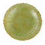 AN EARLY CHINESE SCALLOPED EDGE CELADON SHALLOW DISH with floral and leaf decorated centre 29cm