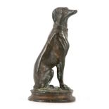 A CAST BRONZE SEATED FIGURE OF A DOG after Barye; on circular base 16cm high