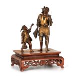 A FINE LATE 19TH CENTURY MEIJI JAPANESE GILT AND PATINATED BRONZE LARGE FIGURE GROUP with a standing