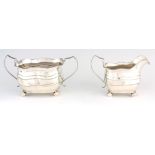 A LARGE GEORGE III TWO-PIECE IRISH SILVER CREAM AND SUGAR BASIN with gadrooned scallop edge and