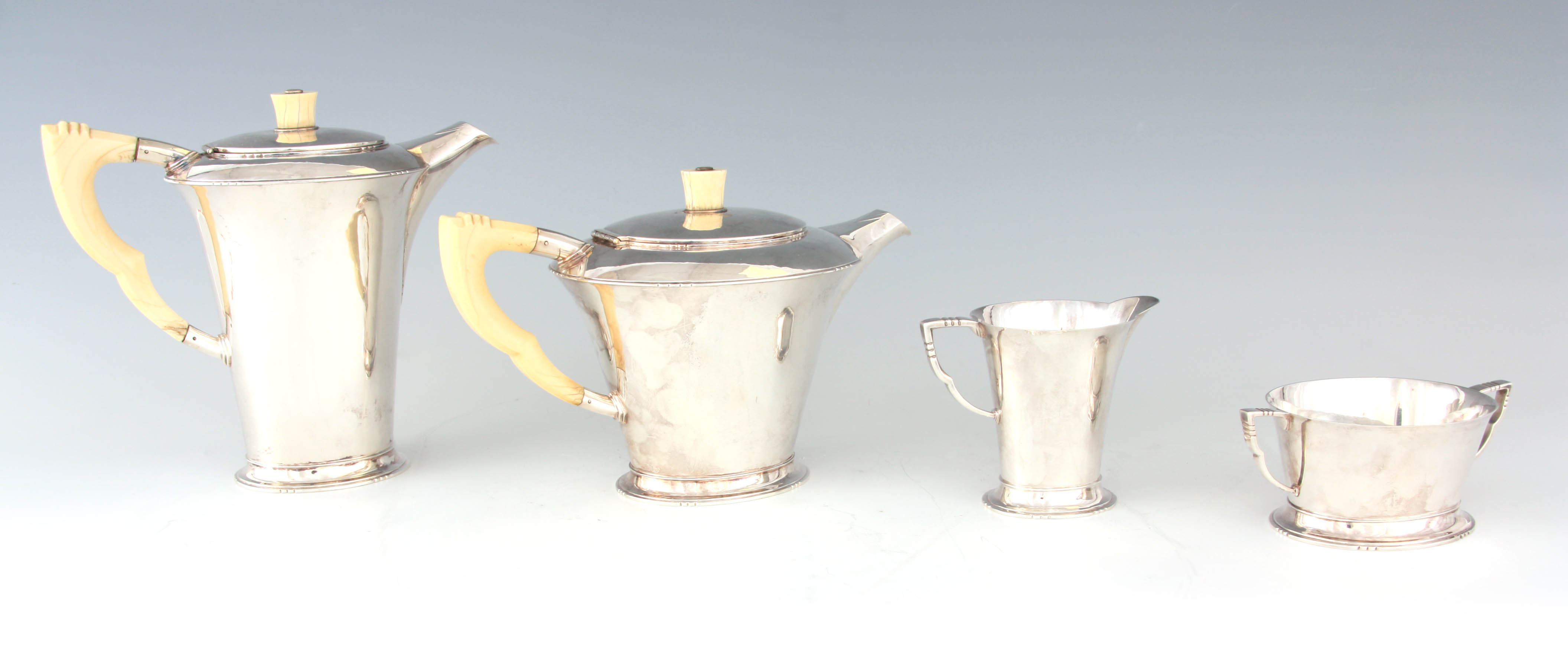 A GEORGE VI FOUR PIECE SILVER TEA AND COFFEE SERVICE OF ART DECO DESIGN the plain tapering bodies