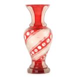 A BOHEMIAN FROSTED AND RED OVERLAY BALUSTER GLASS VASE with faceted foot and neck enclosing a
