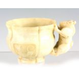 A CHINESE ARCHAISTIC JADE CUP of leaf-shaped form with panelled sides depicting dragons, having a