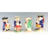 A GROUP OF THREE COLOURFUL SEATED STAFFORDSHIRE TOBY JUGS each clutching a jug of ale 24cm high