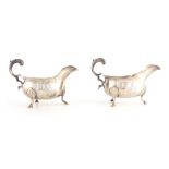 A PAIR OF GEORGE III SILVER SAUCE BOATS with engraved crested armorials and leaf capped double