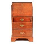 A SMALL MID 18TH CENTURY OAK BUREAU with angled fall revealing a fitted interior of stepped drawers,