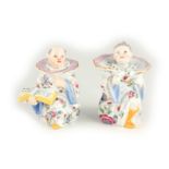 A PAIR OF 19TH CENTURY MEISSEN CHINOISERIE INK AND POUNCE POTS modelled as a girl and boy with