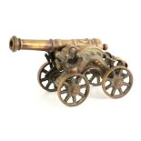 A 19TH CENTURY BRONZE STARTING CANNON mounted on a carriage with dragon decoration 46cm wide overall