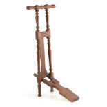 AN UNUSUAL 19TH CENTURY OAK BOOT JACK BY PEAL & CO. LONDON with hinged boot section, turned arms and