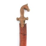 A 19TH CENTURY INDIAN TULWAR SWORD having a copper handle formed as a horse head on a curved