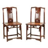 A PAIR OF 18TH CENTURY CHINESE HARDWOOD SIDE CHAIRS with shaped panelled backs above panelled rush