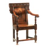 A LATE 17TH CENTURY JOINED OAK OPEN ARMCHAIR with scroll and flowerhead carved eared cresting rail