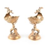 A PAIR OF GEORGE V SILVER GILT TABLE SALTS with shell-shaped bowls supported by heraldic unicorns