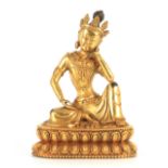 A GILT BRONZE TIBETAN BUDDHA depicting a seated Deity, on a moulded base 20cm high