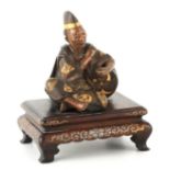 A LATE 19TH CENTURY MEIJI JAPANESE MULTICOLOURED BRONZE SEATED MALE FIGURE BY MIYAO in a cross-
