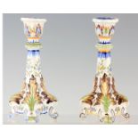 A PAIR OF FRENCH FAIENCE POTTERY CANDLESTICKS decorated with polychrome colours, having scrolled