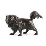 A MEIJI PERIOD JAPANESE PATINATED AND GILT BRONZE MODEL OF A PEKINESE DOG with tied neck collar