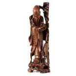 A LATE 19TH CENTURY CHINESE CARVED HARDWOOD STATUE depicting an old wise man with a crane,