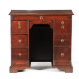 A QUEEN ANNE OAK KNEEHOLE DESK the moulded edge top above a dummy top drawer and two banks of