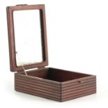 A CHINESE HARDWOOD DRESSING TABLE BOX with hinged mirrored lid, reeded sides and shaped brass