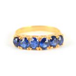 A LADIES SIX STONE BURMESE SAPPHIRE RING having cushion setting in a yellow gold shank