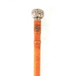 AN EARLY 20TH CENTURY SILVER TOPPED WALKING STICK with birds eye maple shaft and repousse work