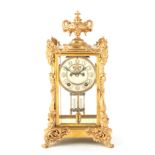 A LATE 19TH CENTURY AMERICAN FOUR-GLASS MANTEL CLOCK the rococo style gilt brass case with urn