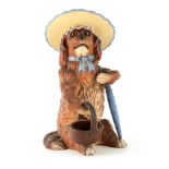 A LATE 19TH CENTURY POLYCHROME TERRACOTTA FIGURE modelled as a seated dog wearing a sun hat with
