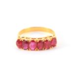 A LADIES SIX STONE BURMESE RUBY RING cushion set in a yellow gold shank