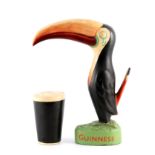 A LARGE GUINNESS ADVERTISING TOUCAN with orange beak, on a naturalistic base with original pint