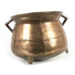 A 17TH CENTURY CAST BRONZE WEST COUNTRY TWO HANDLED CAULDRON on three peg feet 36cm across handles