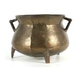 A 17TH CENTURY CAST BRONZE WEST COUNTRY TWO HANDLED CAULDRON on three peg feet, 34.5 cm across