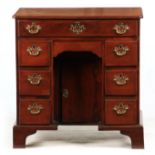 A MID 18TH CENTURY MAHOGANY KNEEHOLE DESK with inverted corners to the top above a long frieze