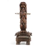 A 19TH CENTURY BLACK FOREST CARVED DOG AND WHIP UMBRELLA/STICK STAND finely modelled standing in a