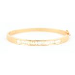 A LADIES 18CT YELLOW AND DIAMOND SET HINGED BANGLE set with 25 baguette-cut diamonds app. 4ct, total